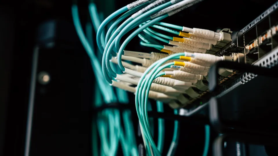 Nahaufnahme von Netzwerkkabeln an einem Server-Rack als Symbol für die technische Übergabe einer IT-Umgebung