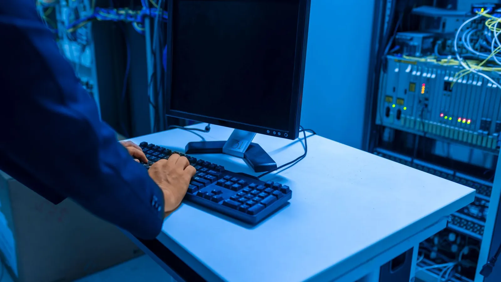 IT-Techniker überwacht an einem Arbeitsplatz Systeme in einem Serverraum